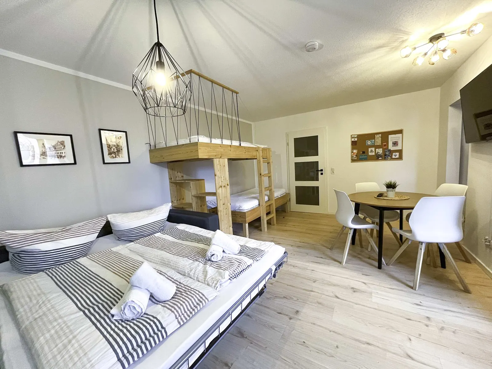Living and sleeping room of the Stadtnest with sofa bed, loft bed and dining table