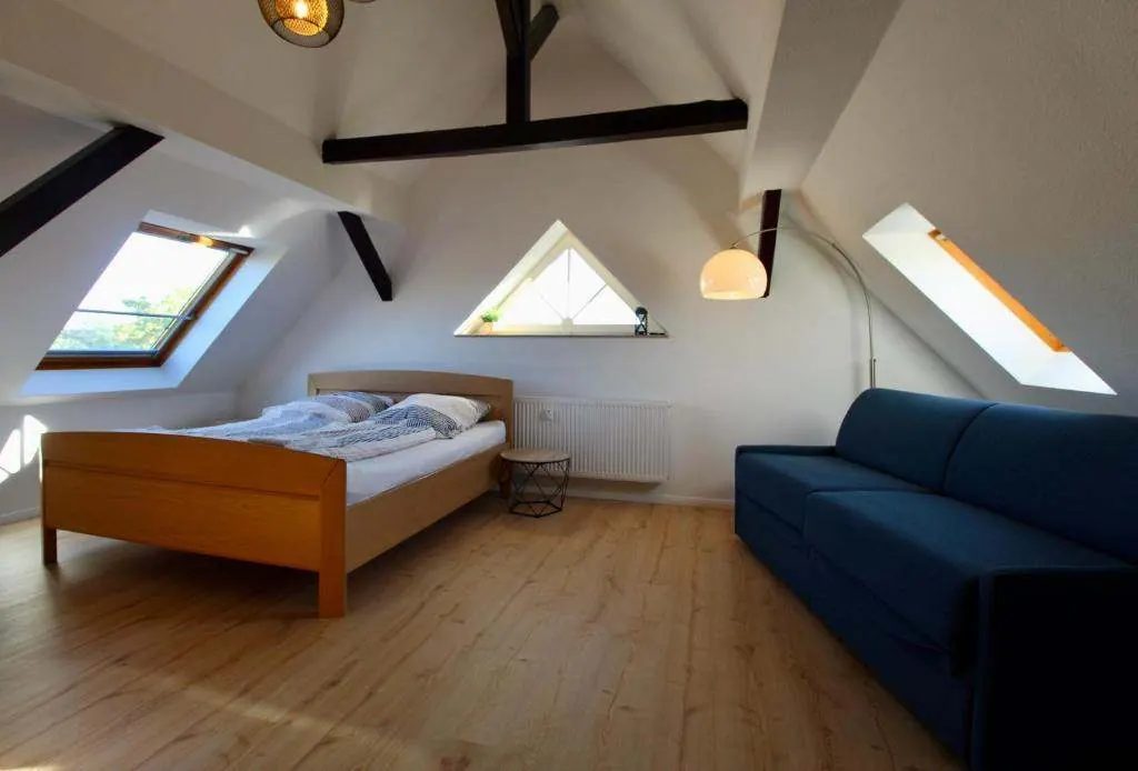 Living and sleeping room under the roof with double bed and sofa bed